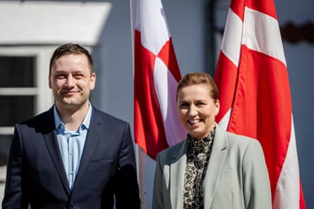 Jens-Frederik Nielsen and Mette Frederiksen stood in front of flags