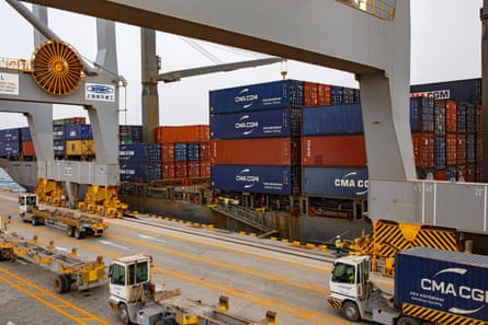 A ship piled high with red and blue containers.