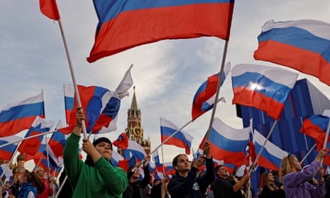 People wave Russian flags in Red Square in Moscow.