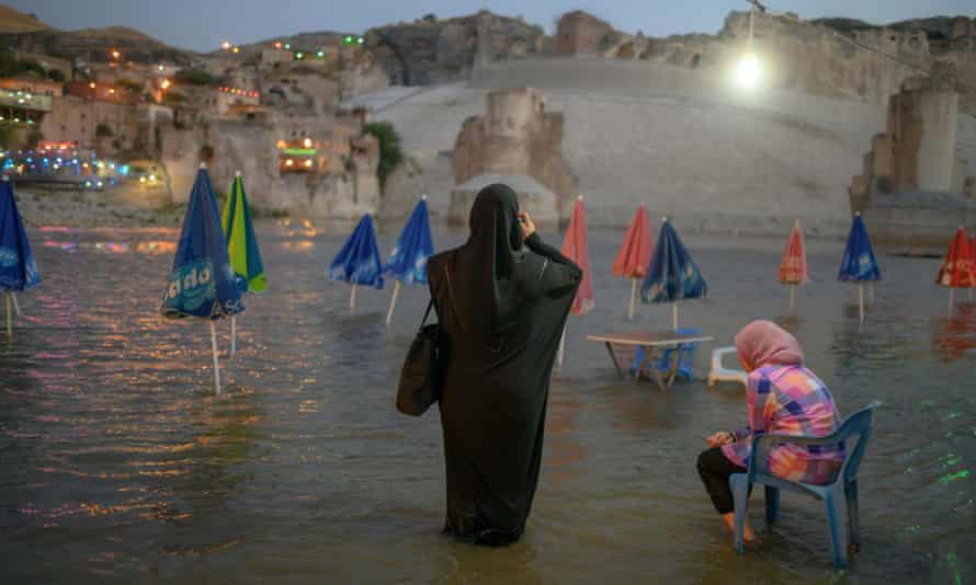 A woman takes a picture of the 12,000-years ancient city of Hasankeyf, on the banks of the Tigris, that has been swallowed by a controversial dam project.