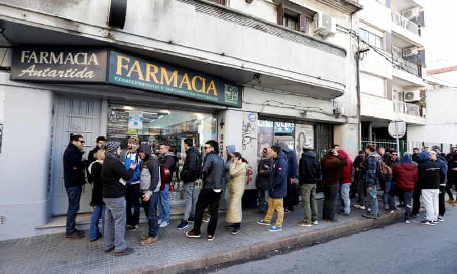 Uruguayans queue in line outside of a pharmacy to buy legal marijuana in Montevideo