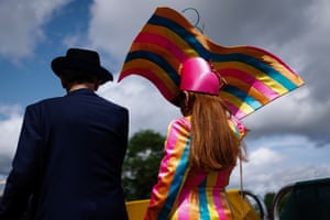 Two racegoers wear hats and one is in colourful attire