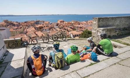 Bikers sitting on steps above Piran and the Adriatic
