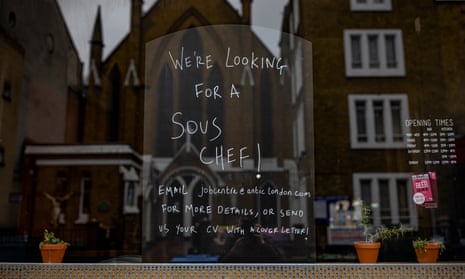 Writing in a restaurant window advertises a sous chef vacancy