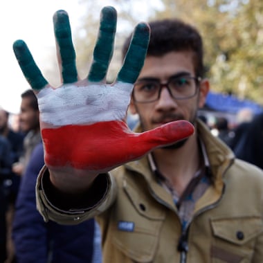 An Iranian man shows his hand painted with Iran’s national flag colours during the anti-US demonstration.
