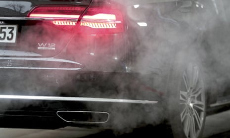 Luxury Audi car surrounded by exhaust gases as it is parked with a running engine in front of the Chancellery in Berlin, Germany