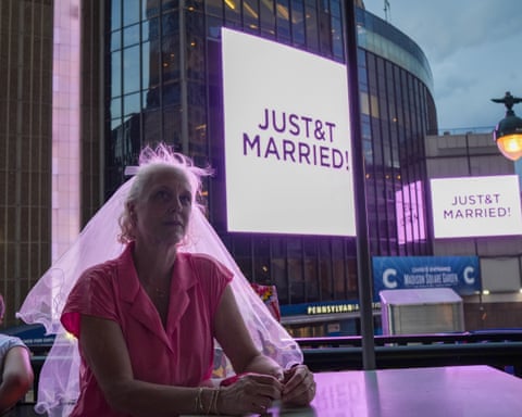A Taylor Swift fan wearing a wedding veil next to Madison Square Garden where a "JUST&T MARRIED" sign is displayed during the wedding between singer Swift and NFL player Travis Kelce