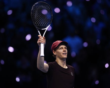 Jannik Sinner raises his racket to acknowledge the crowd as he celebrates after winning his semi-final against Alex de Minaur.