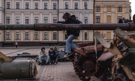 Young men sit next to destroyed Russian military vehicles on display in Mykhailivskyi Square, in Kyiv Ukraine, on 24 April 2023.