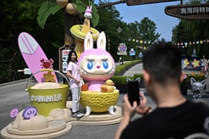 A woman poses for a picture next to the character Mokoko
