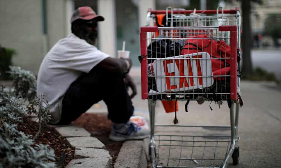 A homeless man sits next to a shopping cart as the spread of Covid-19 continues, in New Orleans, Louisiana, last week.