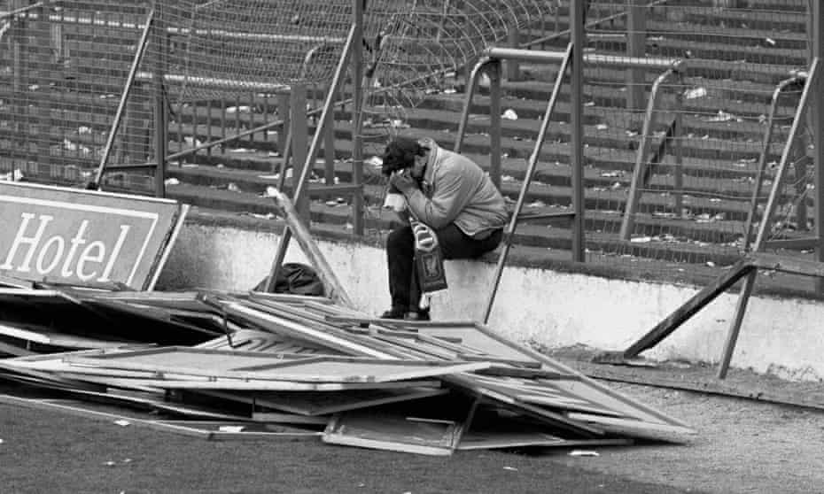 A Liverpool fan sits in the empty Hillsborough stadium on 15 April 1989 following the disaster which killed 96 people