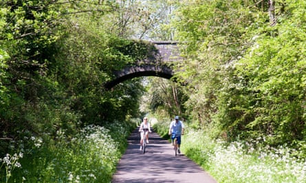 A couple cycling on the Bristol and Bath Railway Path in spring.