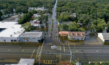 In an aerial view of Crystal River, Florida, a vehicle drives through a flooded street in the downtown area after Hurricane Idalia passed offshore.