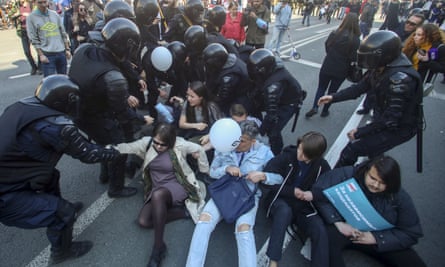 Riot police try to detain protesters during a rally in St Petersburg
