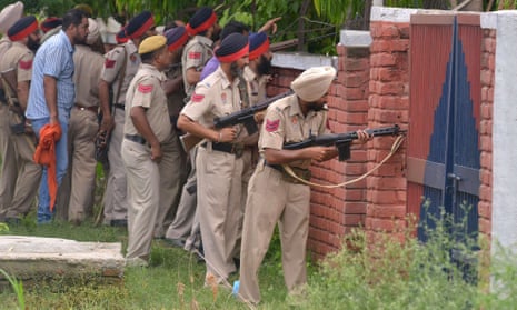 Police personnel take up positions outside the building in Gurdaspur.