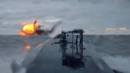 Fireball onboard large ship on horizon in video still from drone.