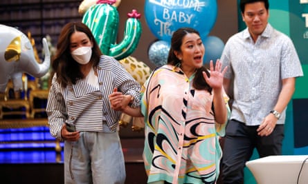 Pheu Thai party’s prime ministerial candidate Paetongtarn Shinawatra waves to journalists as she is escorted by her elder sister Pinthongta and her husband Pidok Sooksawas in Bangkok on 3 May.