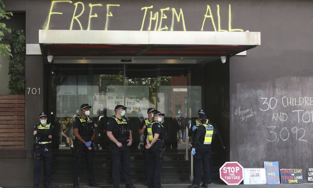 Police guard outside the Park hotel in Melbourne, Australia, where pro-refugee signs and writing can be seen on the hotel's walls