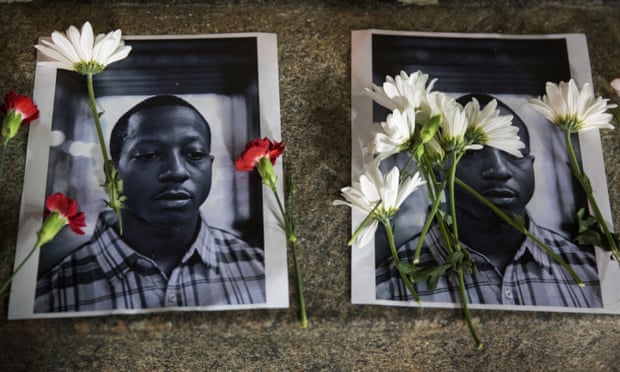Flowers rest on top of pictures of Kalief Browder in New York on 11 June 2015.