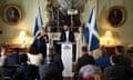 Humza Yousaf speaks from behind a lectern with two Scottish flags either side of him and a sign language interpreter to the left