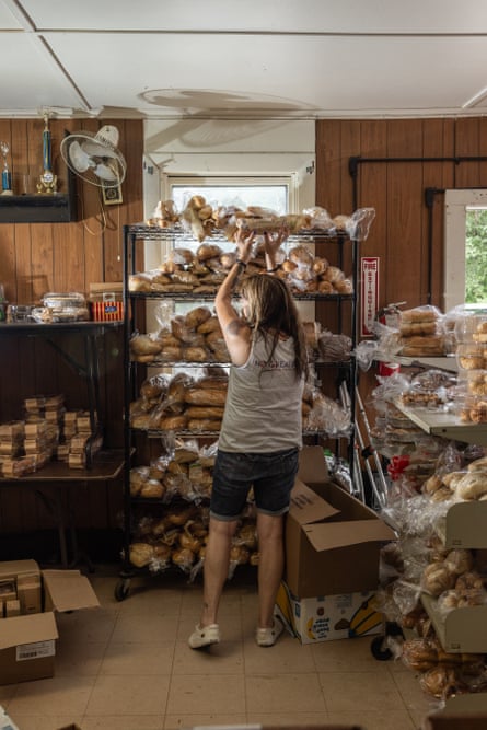 A woman organizes baked goods onto a shelf