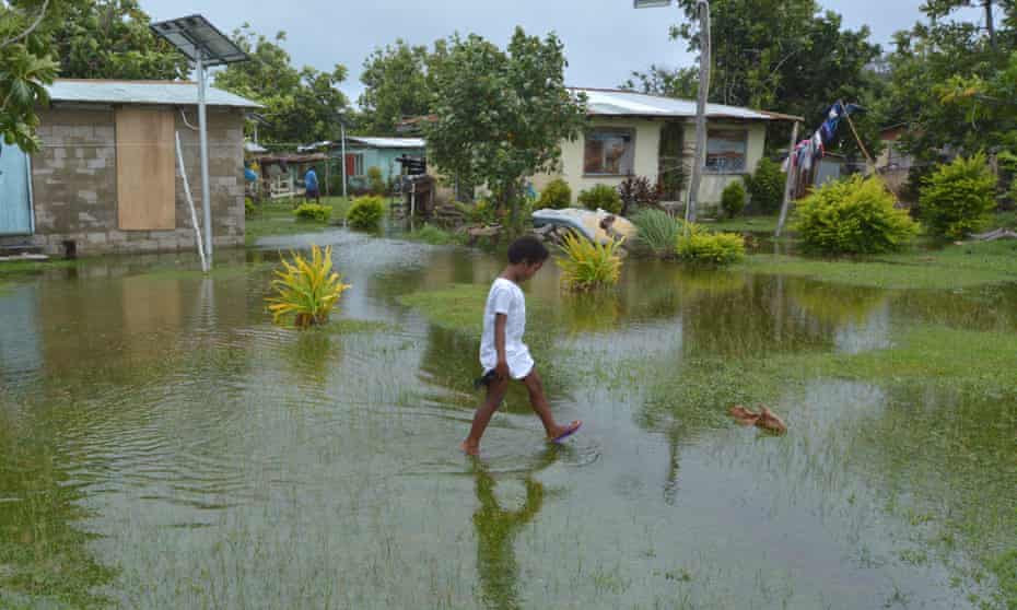 Girl walks over flooded land in Fiji