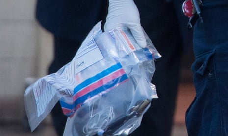 A police officer carrying an evidence bag after drugs raids in south London.