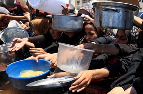 Palestinians gather to receive food from a charity kitchen, amid a hunger crisis, in Gaza City, 24 July 2025.