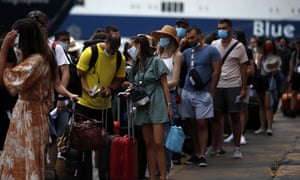 People wearing face masks to prevent the spread of coronavirus wait to board a ferry in the port of Piraeus, near Athens, on Friday, 7 August 2020.
