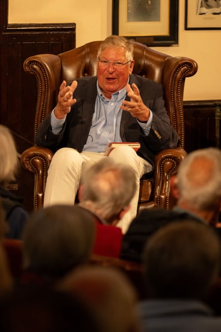 Ed Stourton sitting in a leather chair, addressing a seated audience