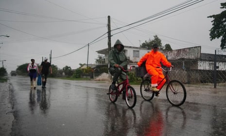 Cubans walking in the rain as Hurricane Ian makes landfall