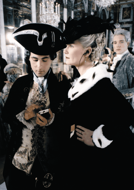 Jason Schwartzman as Louis XVI and Kirsten Dunst as Marie Antoinette listening to something on an iPod.