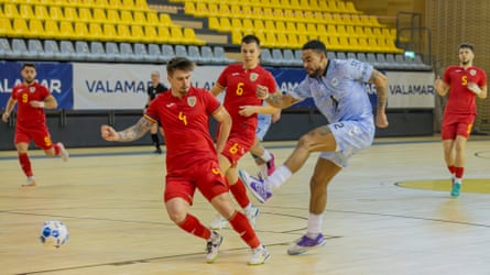 Greenland’s Patrick Frederiksen, in light blue, goes on the attack against Romania.