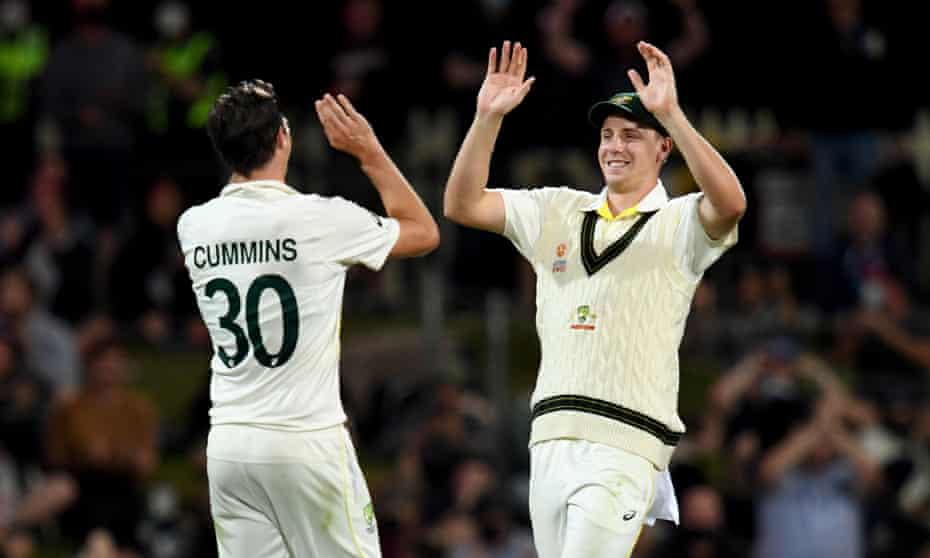 Pat Cummins (left) and Cameron Green celebrate the wicket of Mark Wood in Tasmania.