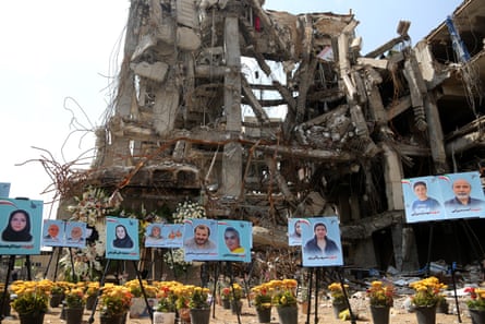 Photos of civilians killed in US-Israeli strikes displayed in front of a destroyed building in Tehran last month.