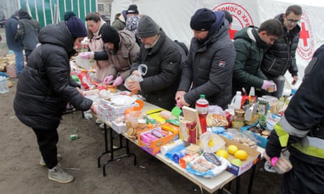 People offer food and drink at a Ukrainian Red Cross Society tent set up outside the apartment block.