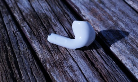 A single earbud of Apple AirPods 4 resting on table.
