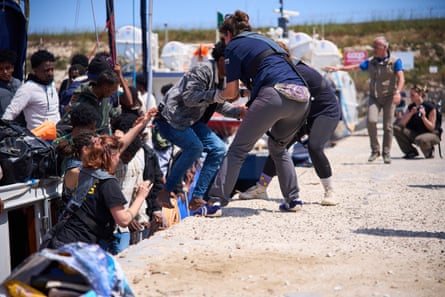People rescued at sea are disembarked from the Nadir.