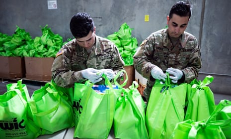 Members of the national guard put food in bags to be delivered to people in need at the Find food bank in Indio, California, on 24 March. 