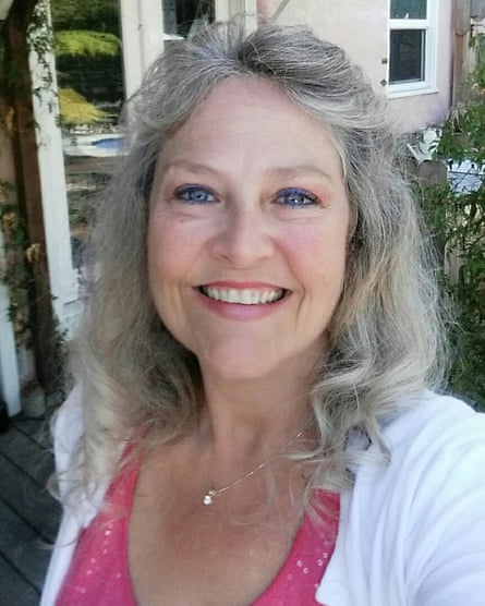 A woman with salt and pepper hair smiling into the camera