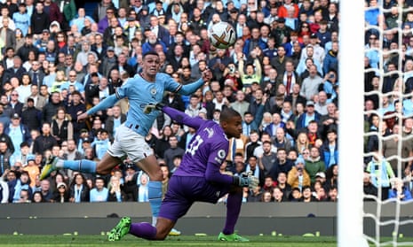 Manchester City's Phil Foden (left) dinks the ball over Southampton's goalkeeper Gavin Bazunu to score their second goal.