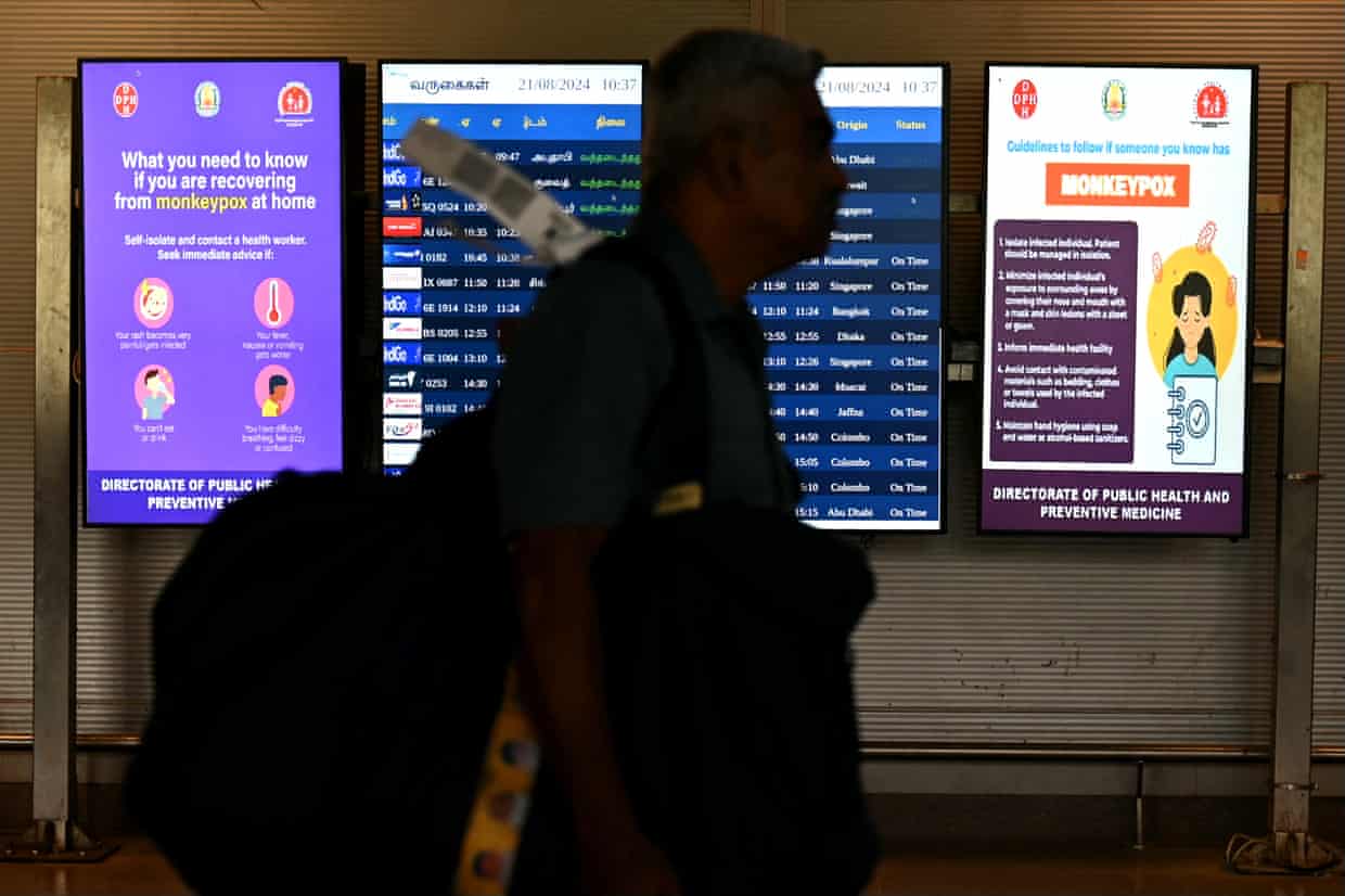 The silhouette of a passenger walking past screens