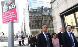 The Irish leader, Leo Varadkar (left), and other ministers walk by a poster using a child with Down’s syndrome to argue against the repeal of the 8th amendment.