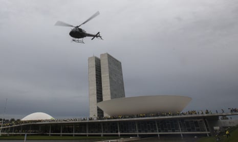 A helicopter flies as supporters of former President Jair Bolsonaro clash with security forces after raiding the National Congress in Brasília, Brazil, 8 January 2023.