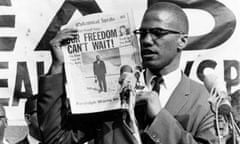 X<br>Black Muslim leader Malcolm X holds up a paper for the crowd to see during a Black Muslim rally in New York City on Aug. 6, 1963. (AP Photo)