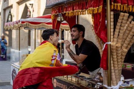 An ice-cream vendor feeds a fan of Spain at the market in Doha.