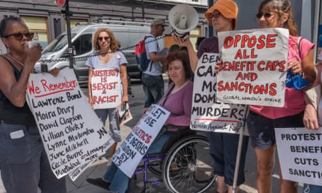 People protest outside a jobcentre in Kentish Town, London, against benefit cuts