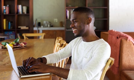 Portrait of young African man working on laptop indoors