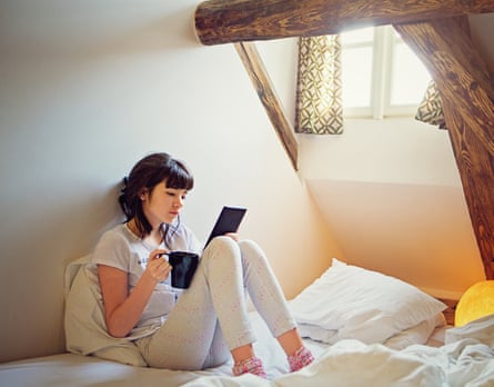 A teenage girl reading an e-book in a corner